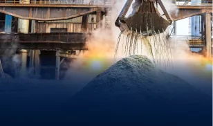 Industrial crane pouring cement aggregate material from a height at a processing plant