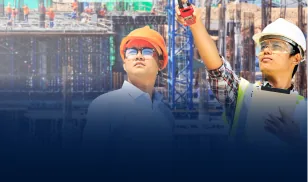Two construction engineers in helmets inspecting a building structure at a job site